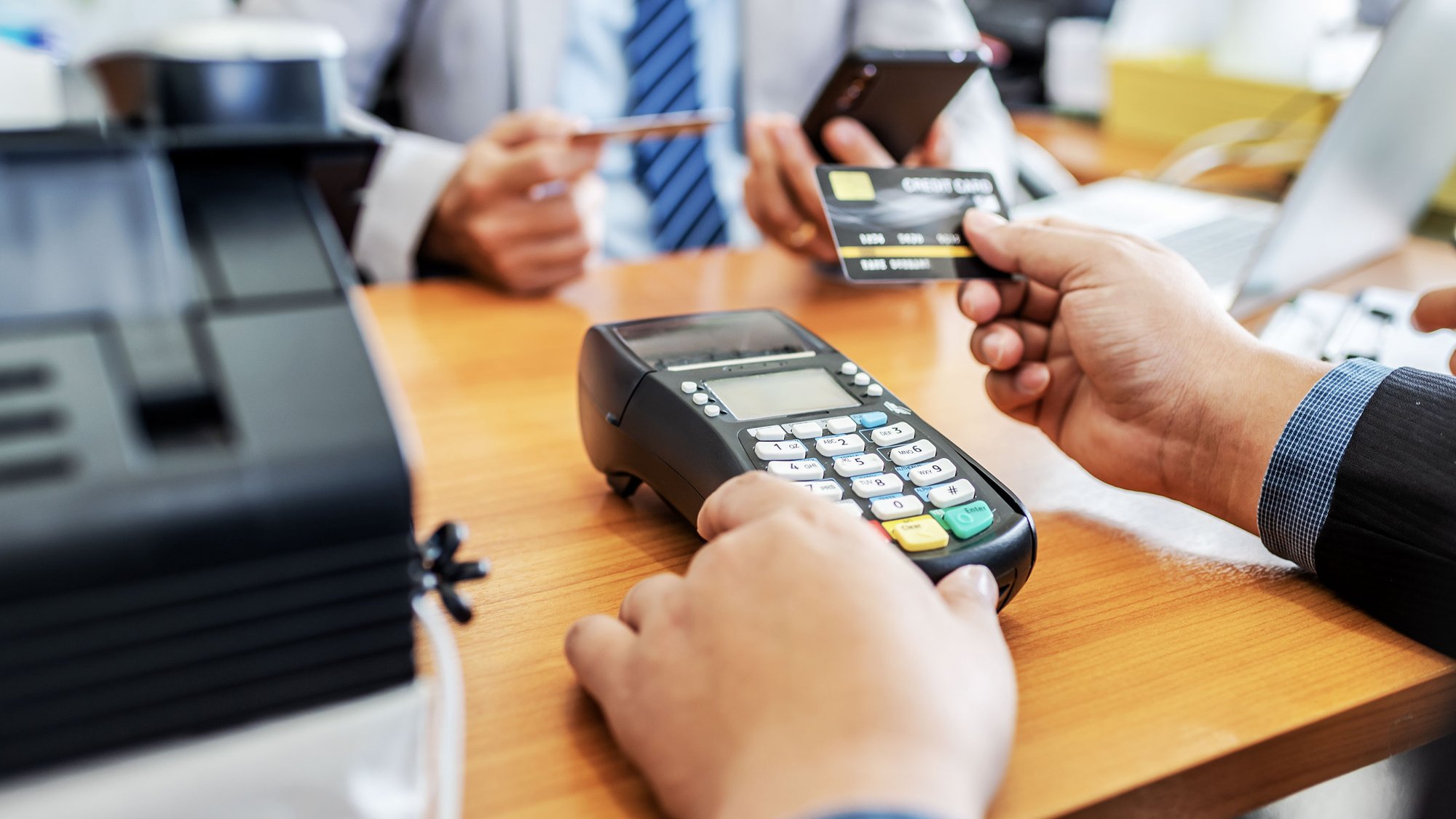 A person paying with a credit card on a POS terminal