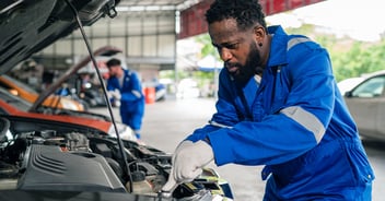 Auto mechanic installing parts on a car.
