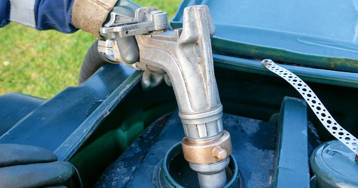 Person using a manual hand pump to fill a residential fuel tank.